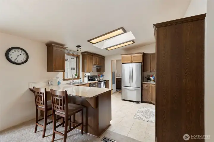 Kitchen eating bar is the perfect place for you friends to sit and visit as food is prepared in the kitchen. The vaulted ceiling and skylights are a great touch making the home feel spacious and well-lit.