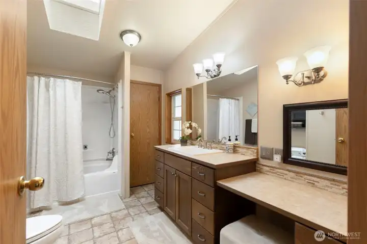 Primary private bath with makeup vanity, sink, tub/shower combo and linen closet..