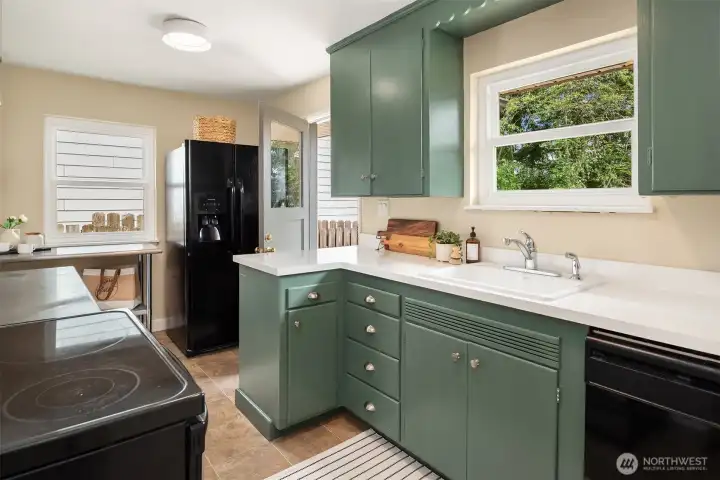 The large kitchen features original (just painted) cabinets plus stainless steel open shelving.