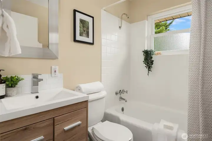 Nice sized full bath with a refiished bathtub and tile surround.