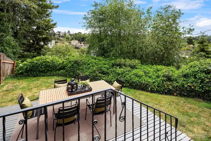 The private backyard has an elevated wood deck and nice green space that goes all the way to the paved alley.