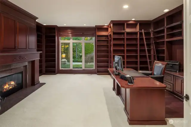 executive office with wrap around book shelf, fireplace & even a rolling ladder