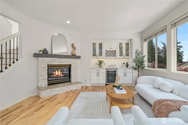 A sun-drenched main-level living room features a warm gas fireplace, creating an inviting and elegant space.