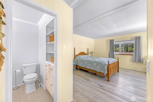 Looking into primary bedroom and primary bathroom from dressing room