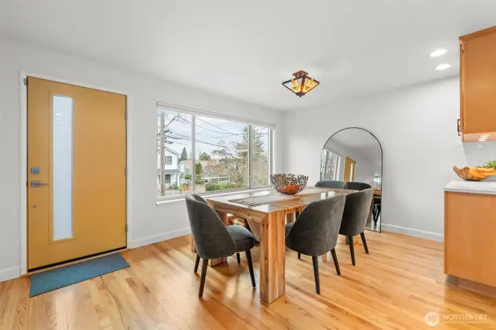 Dining room positioned directly off the kitchen for seamless service and effortless flow during gatherings. A distinctive architectural light fixture adds design presence, while the open layout makes this space ideal for elevated entertaining