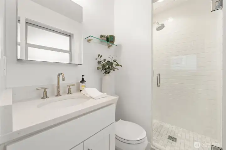 Primary bath taken to the studs and fully remodeled in 2019 with contemporary tile, glass-enclosed shower, and updated fixtures. A clean, modern design delivers both daily comfort and long-term value.