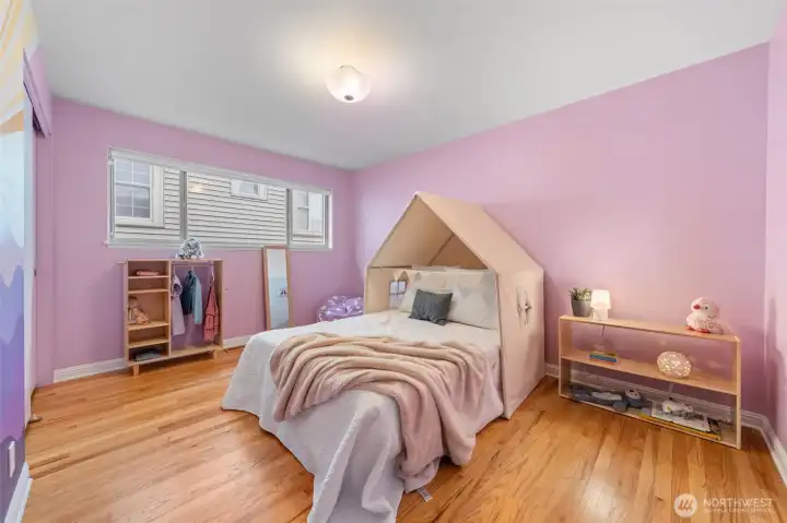 Bedroom Two offers generous proportions, hardwood floors, and a wide window that brings in natural light. A versatile layout accommodates bedroom, guest suite, or office use while maintaining the home’s clean, modern aesthetic