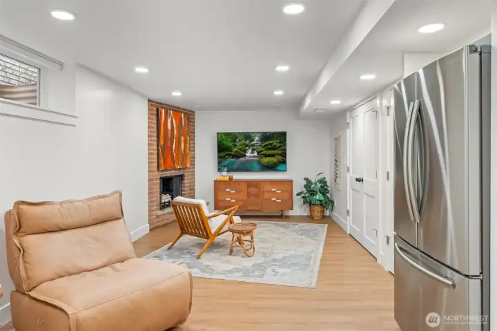 Fully permitted lower-level ADU featuring private living space, recessed lighting, and a brick fireplace that adds architectural depth. Complete with separate entry, kitchen, and laundry capability, this space is ideal for multigenerational living or income-producing flexibility. Notice the LVP flooring throughout this space and into the bedrooms.