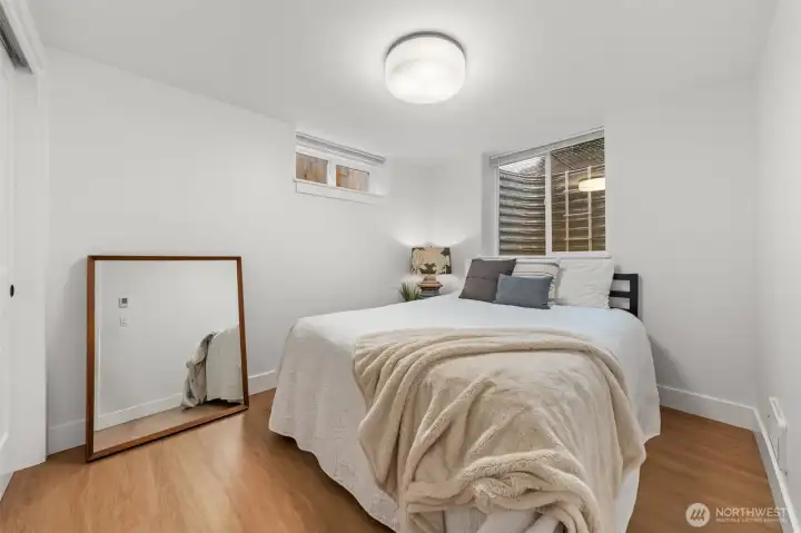 Lower-level Bedroom Five offers privacy and versatility within the fully permitted ADU, complete with modern finishes, large closet, recessed lighting and LVP flooring.