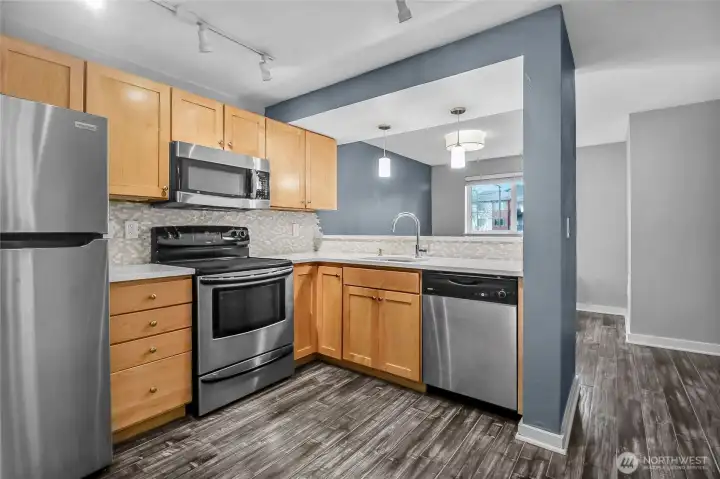 Spacious kitchen with upgraded quartz countertops, custom tile backsplash, and counter pendant lighting.