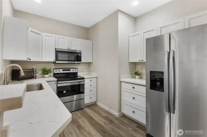 The open concept kitchen is designed for both everyday living and effortless entertaining. Quartz countertops provide generous prep space along with convenient bar seating for