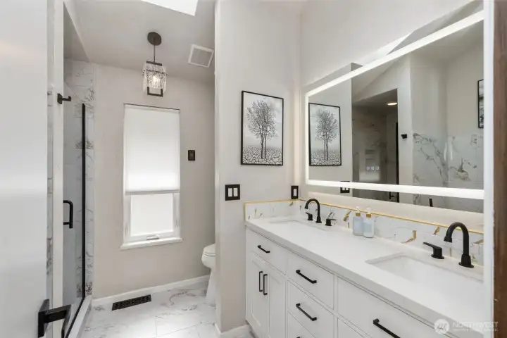 Stunning 5 piece en-suite bath with heated floors, custom tiles, mirror and soaking tub.