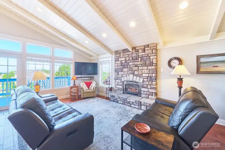 Upstairs, the great room is anchored by a striking stone fireplace surround. The vented propane system efficiently helps to heat the home, combining comfort with architectural presence.