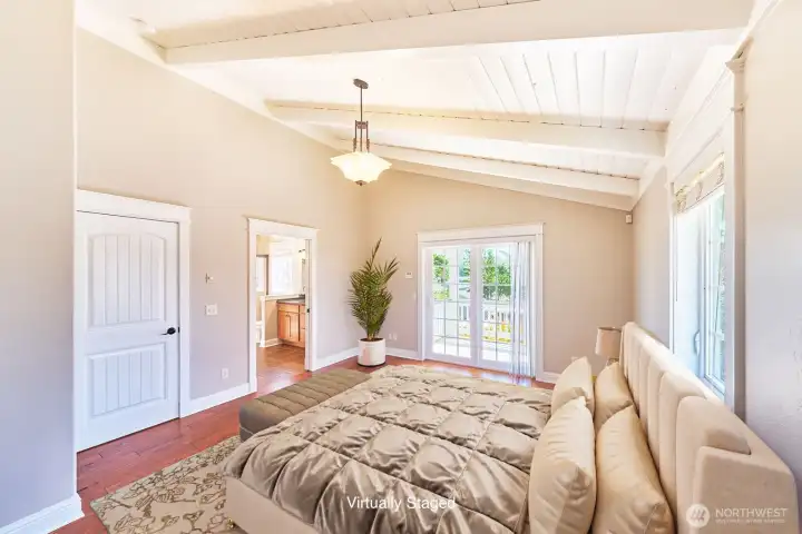 The primary suite is a serene retreat, featuring vaulted ceilings and abundant light.