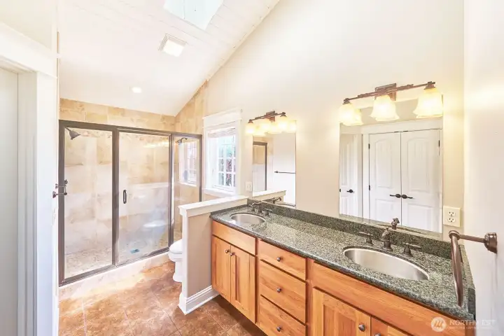 The luxurious primary bathroom has granite finishes and an expansive walk-in shower designed for relaxation after a busy day.s