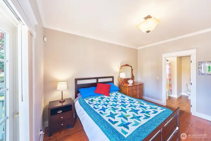 A spacious bedroom with private en-suite bath and direct access to the back deck, offers privacy and comfort for guests.
