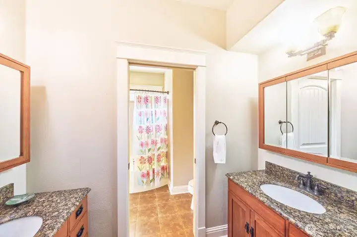 Pocket doors provide privacy while revealing dual sinks.