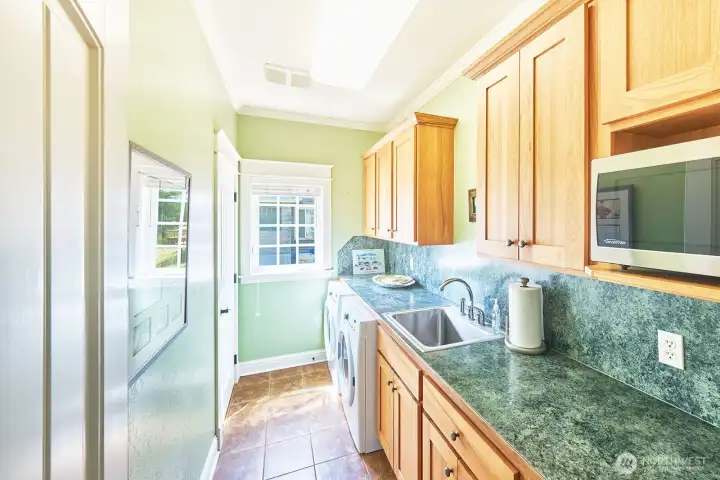 A convenient mini kitchen, laundry room with utility sink, and on-demand hot water system enhance flexibility and efficiency.