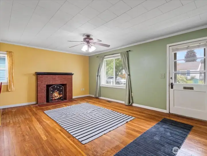 Living room, hardwood floors, ceiling fan, wood-burning fireplace