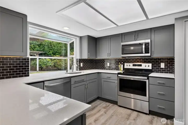 Stainless steel appliances & subway tile add to the contemorary feel, while the garden window provides a southern exposure, perfect for growing herbs! A handy pantry is just to the right of the cabinetry.