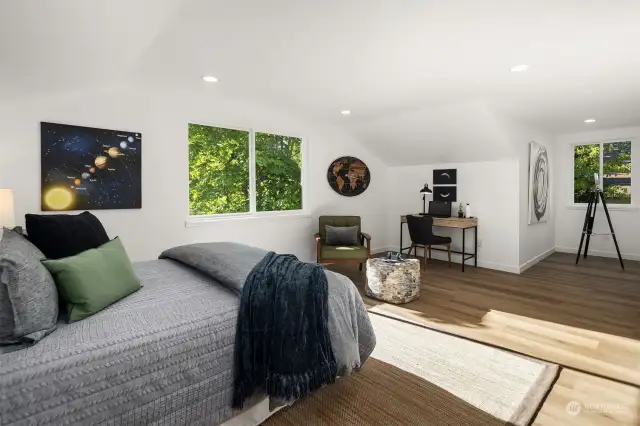 One of the two expansive bedrooms bookend the upper level, complemented by a shared play/bonus space and a full bathroom.