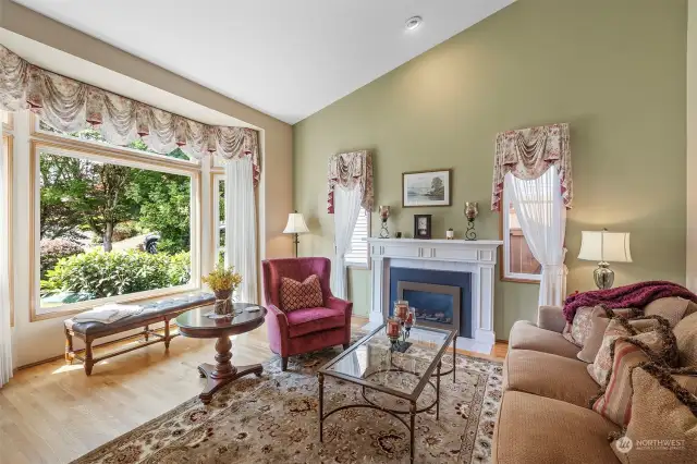 Vaulted ceiling, gas fireplace and expansive window are enjoyed in the formal living room