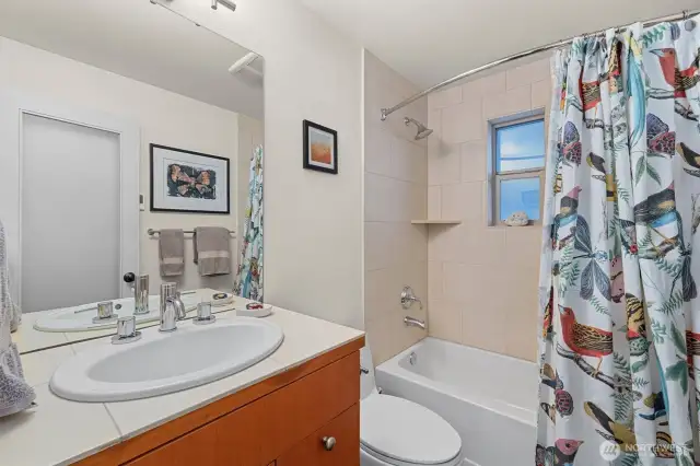 Full bath on main floor has heated slate floors, travertine countertop at sink.