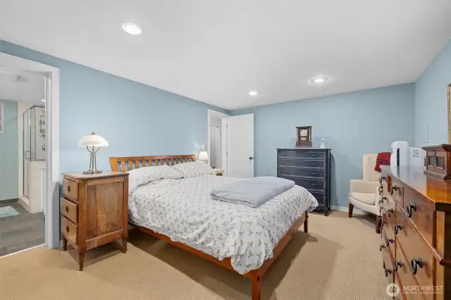 Primary bedroom on lower level. To the left is the full bath with tub and separate shower. Heated slate floors.