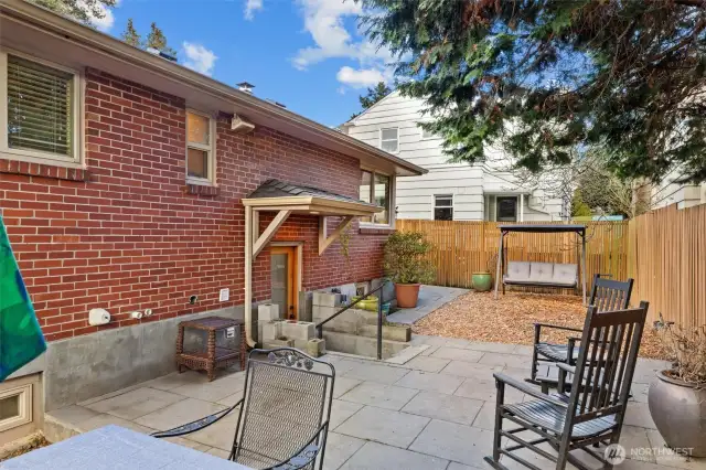 The back patio has defined areas for play (or gardening) and paved patio for the cook and guests to relax in the southern sun.