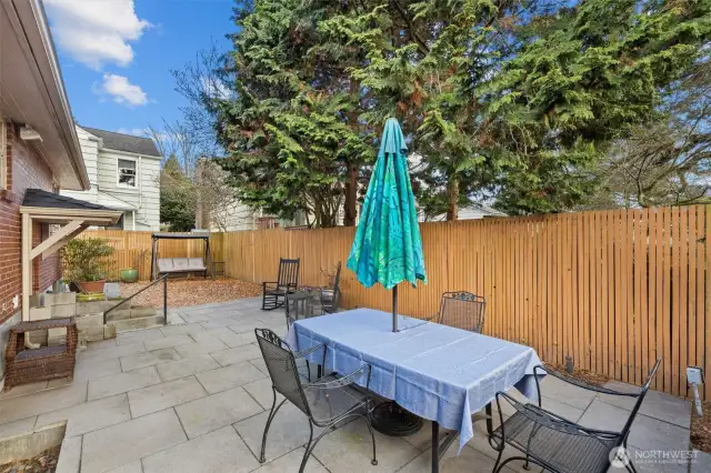The patio is large enough for a big table to entertain. At night lights illuminate the area along the fence.