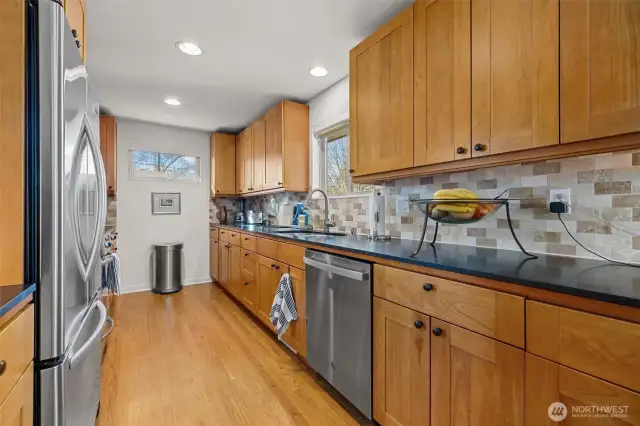Open kitchen for the cook to be among family and guests. Shaker style solid cherry cabinetry, honed granite countertops, tumbled-faced marble subway backsplash.