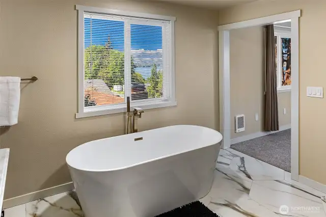 Large soaking tub capturing lake views.