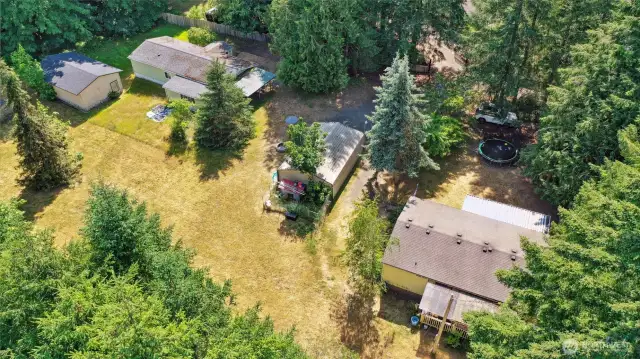 Two double-wide manufactured homes sit on the west side of the property, as well as a carport (center photo) and large barn/shed (left photo).