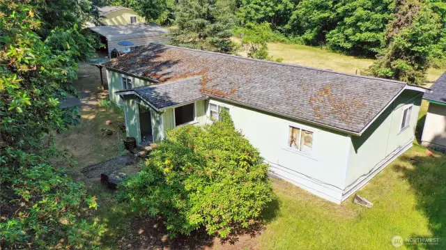 This particular view of 6325 shows the proximity of the yellow house (6321), carport, and the corner of the shed/barn structure, as well as the wide open side of the property behind them.