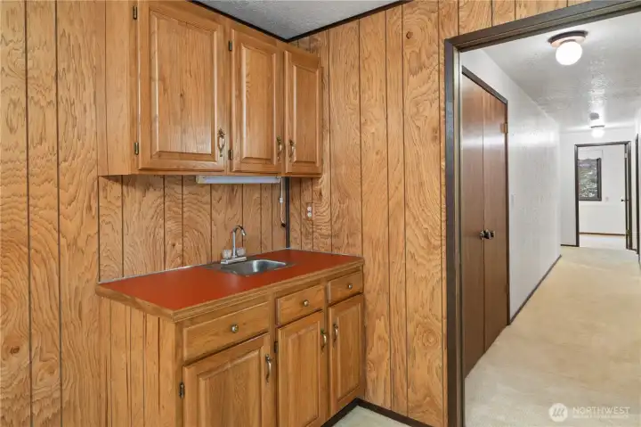 The wet bar in the lower level rec room. Down the hall are two guest bedrooms and the laundry room is in the background.