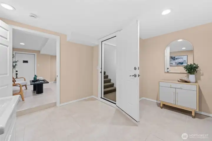 The lower level entry is bright, well-laid-out, and connects seamlessly to both the bonus room and the staircase to the main floor. A stylish entry console and arched mirror set a welcoming tone the moment you walk in.