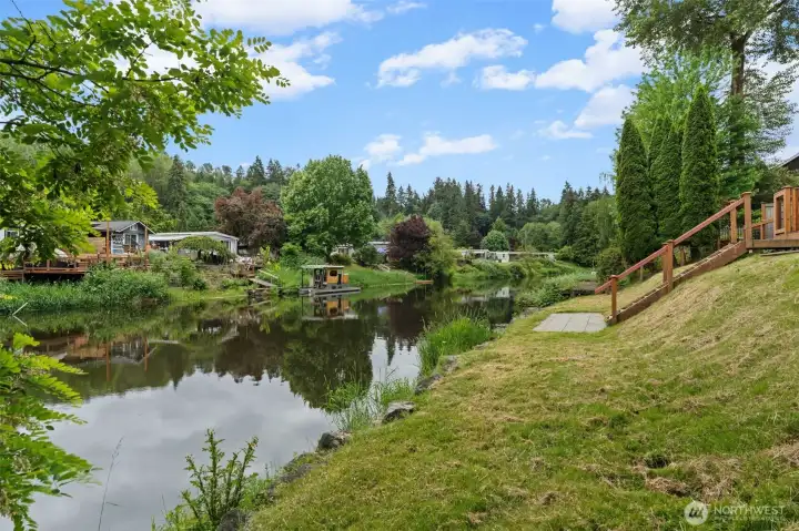 Peaceful river views stretch across the backyard, reflecting the sky and surrounding greenery for a truly tranquil everyday experience.