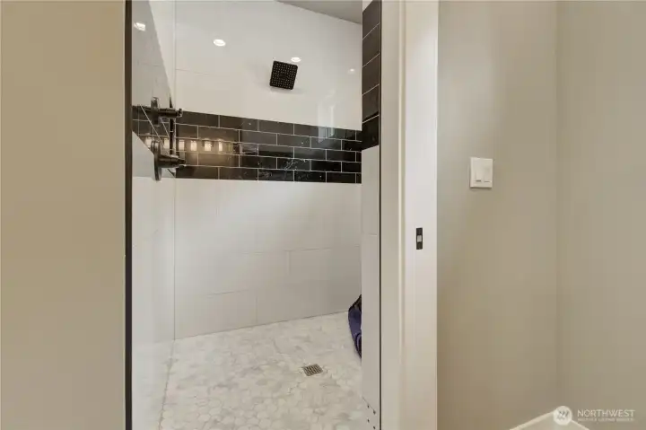 Tile matches throughout the home with tall showerheads. Tile matches throughout the home with tall showerheads.
