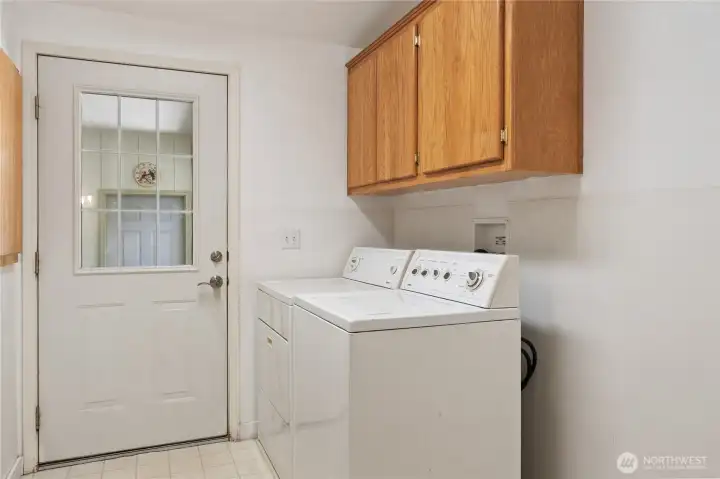 Laundry room with a door leading to the backyard.