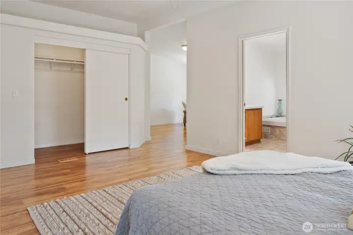 Flooring is clean and fresh throughout the home.  Primary walk-in closet and the room to the right is the primary bedroom continuing.