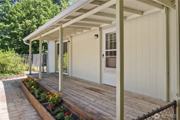 Back covered deck leads to fenced courtyard.