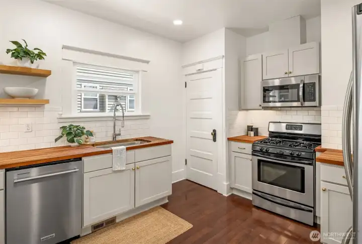 Bright and cheerful kitchen with butcher block counters and under-cabinet lighting. Bright and cheerful kitchen with butcher block counters and under-cabinet lighting.