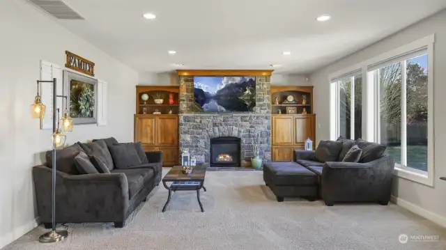 A stunning fireplace serves as the focal point of the great room, complemented by a large window wall for abundant natural light.