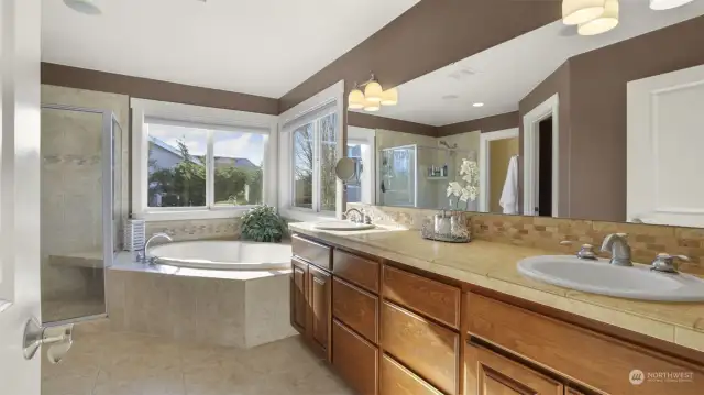 A beautifully appointed master bathroom with elegant wood cabinetry for added charm.