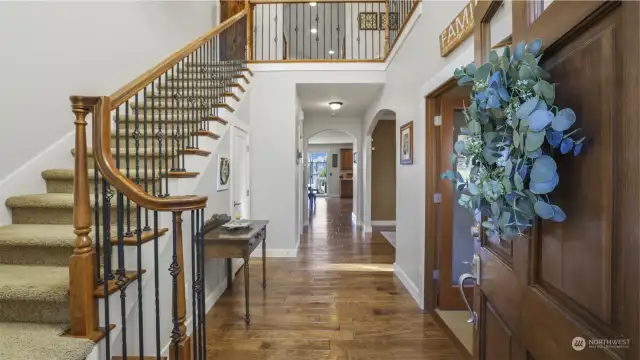 Stunning hardwood floors and rich wood accents, even down to the staircase handle, create a warm and inviting ambiance.