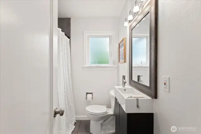 The hall bath offers a clean, modern design with updated fixtures and natural light