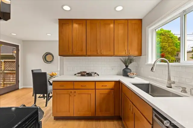 Shaker-style cabinetry, white counters, and subway tile create a fresh yet classic kitchen space.