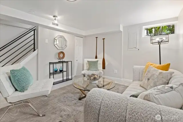 Downstairs, a bright and stylish bonus room invites lounging, movie nights, or casual conversation.