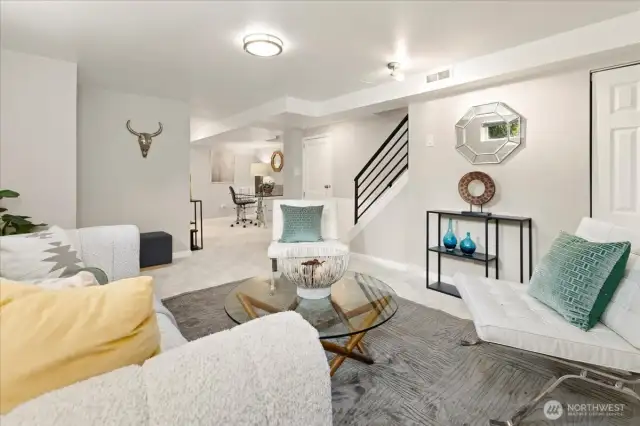 An open-concept lower level offers a secondary living area, perfect for movie nights, lounging, or creative space.