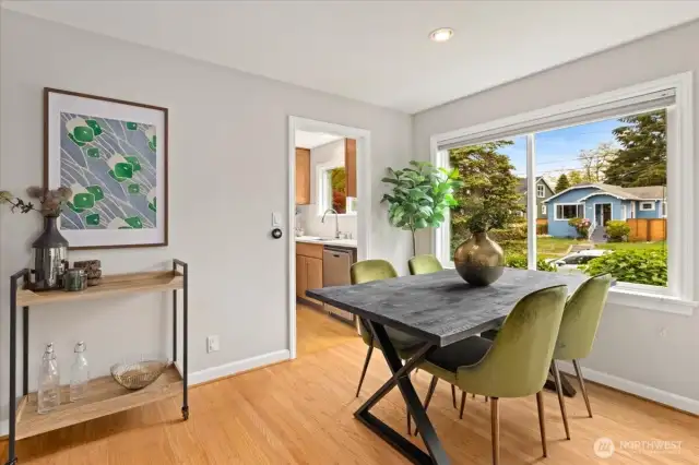 The dining area captures leafy neighborhood scenes through oversized windows and connects easily to the updated kitchen.